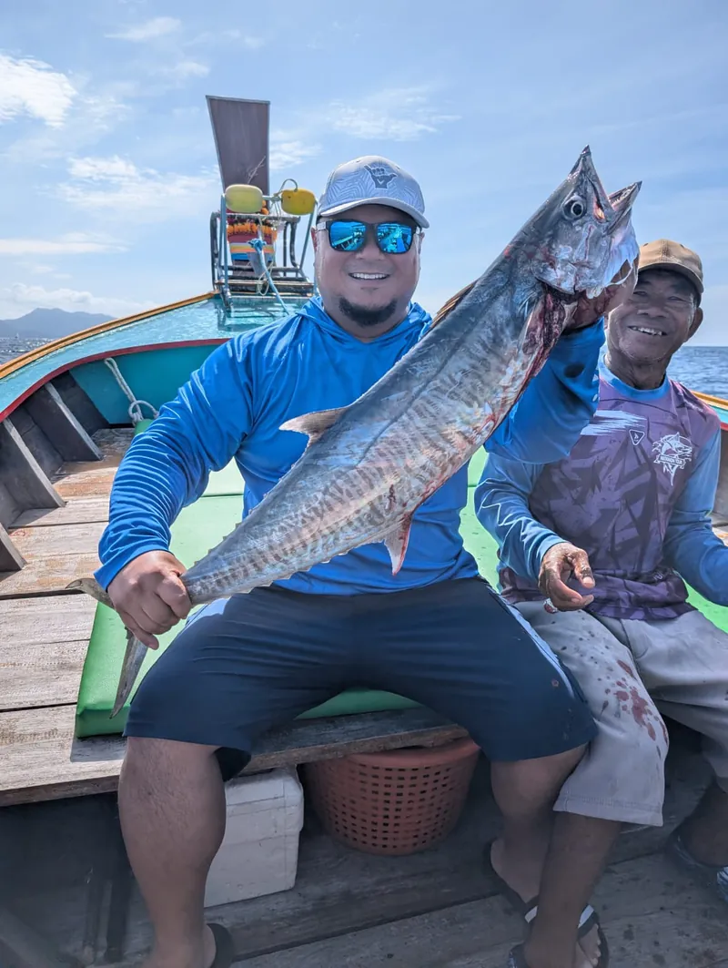 Guest and boatman with a king mackerel on a longtail